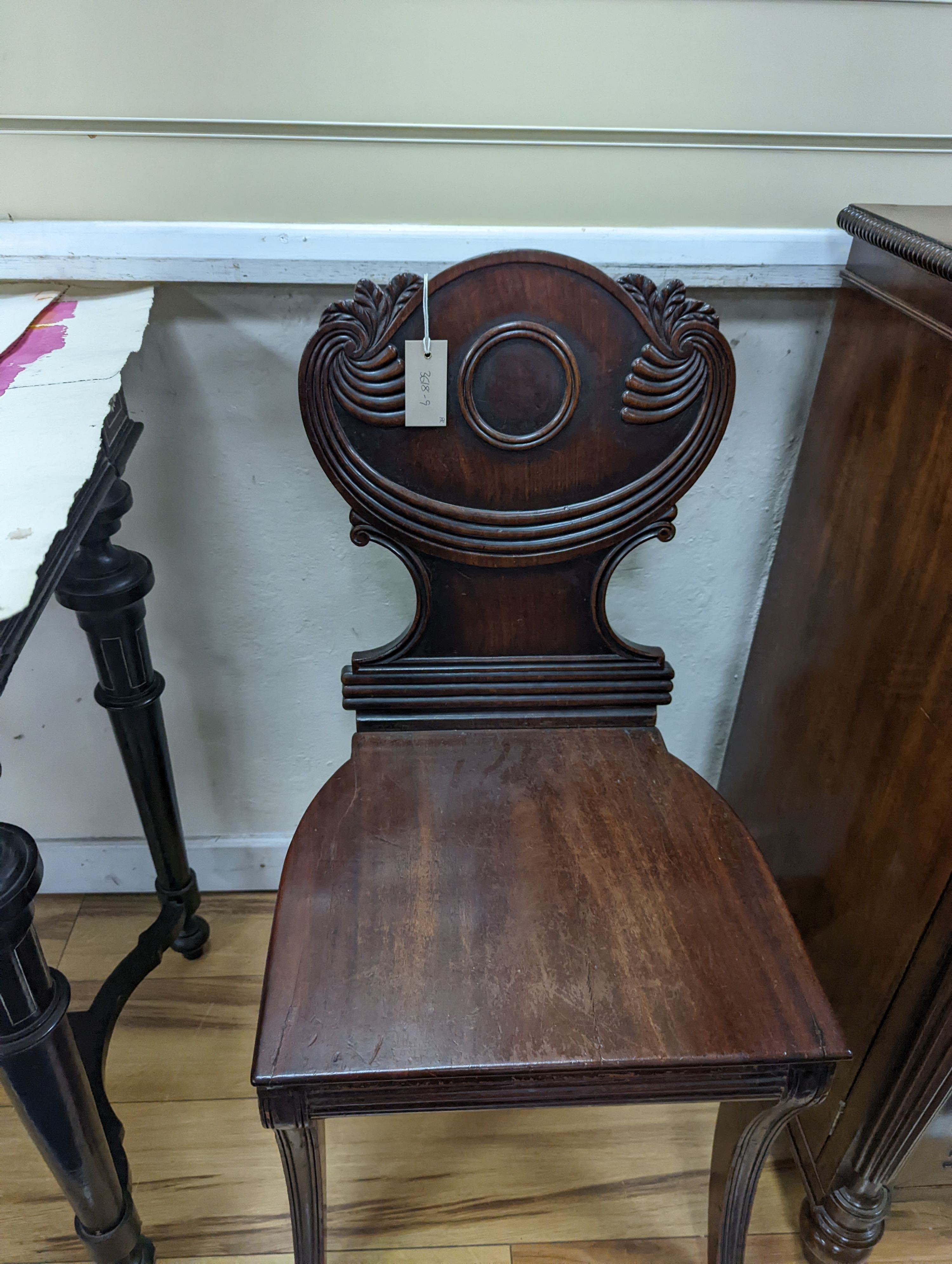 A pair of Regency mahogany sabre leg hall chairs